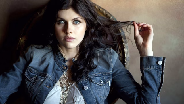 HD-wallpaper-alexandra-daddario-is-wearing-white-top-and-jean-coat-and-leaning-back-on-a-wall-2020-actress-celebrities