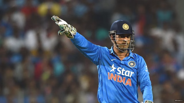 HD-wallpaper-ms-dhoni-is-wearing-blue-sports-dress-and-helmet-standing-in-blur-audience-background-dhoni