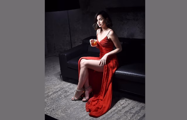 HD-wallpaper-ana-de-armas-hot-red-dress-holding-a-cocktail-brunette-sitting-on-black-leather-couch-high-heels-leg-exposed-spaghetti-straps-split-right-side